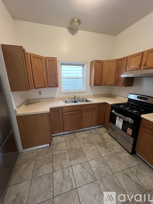 A kitchen with wooden cabinets and a tiled floor.