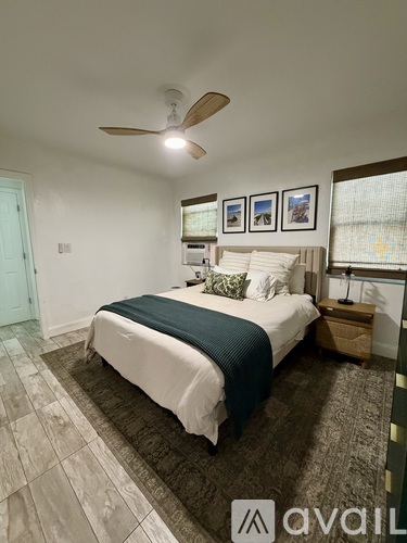 A bedroom with a bed, nightstand, and a ceiling fan.
