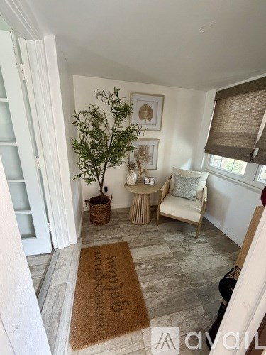 A living room with a tree, a sofa, and a rug that says "HOPE".