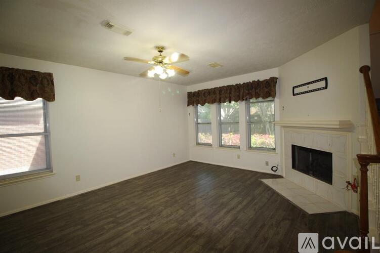 A living room with a fireplace and a ceiling fan.