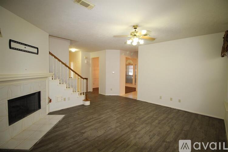 A living room with a fireplace and a staircase.
