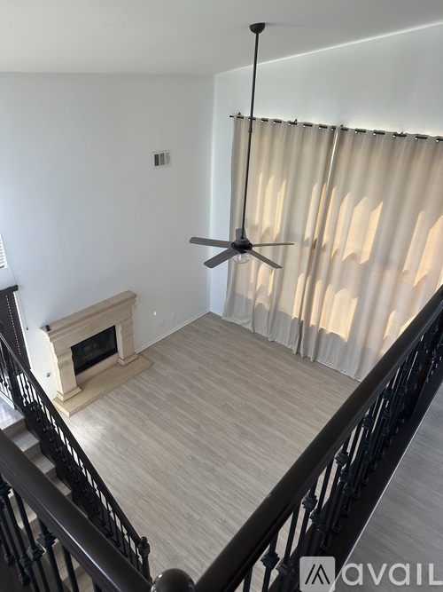 A living room with a fireplace and a fan.