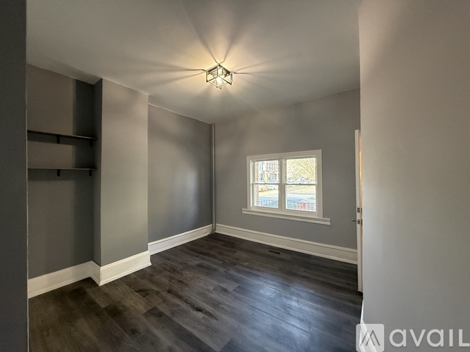 A room with a window and wooden flooring.