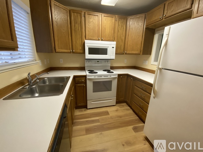 A kitchen with wooden cabinets and white appliances.