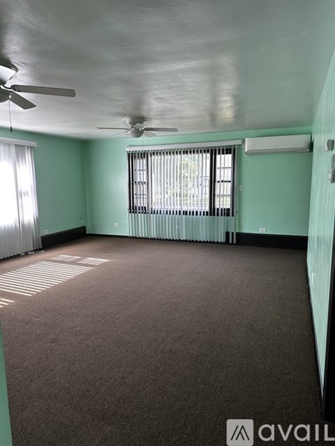 A room with a ceiling fan and a window with blinds.