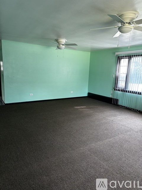 A room with a ceiling fan and carpeted floor.
