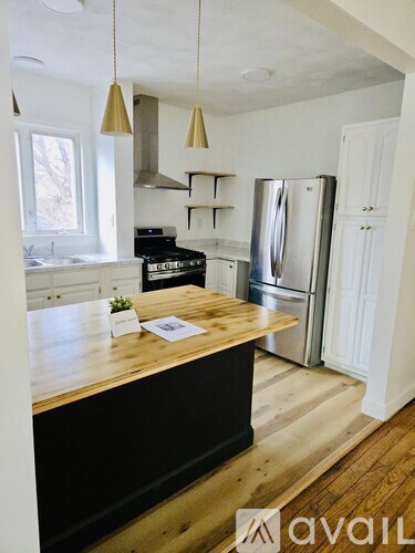 A kitchen with a wooden island and a refrigerator.