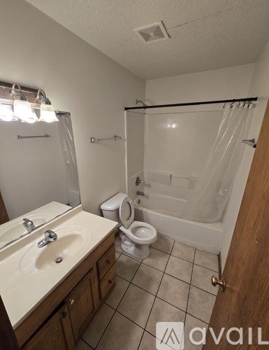 A bathroom with a toilet, sink, and shower.