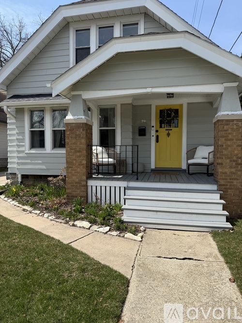A house with a yellow door and a porch.