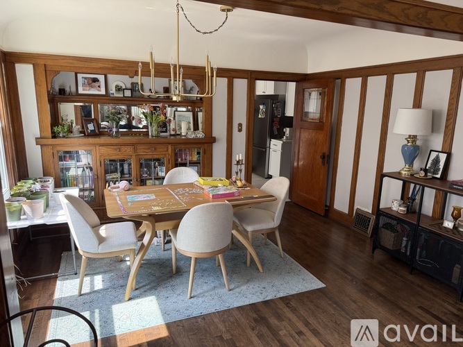 A dining room with a wooden table and chairs.