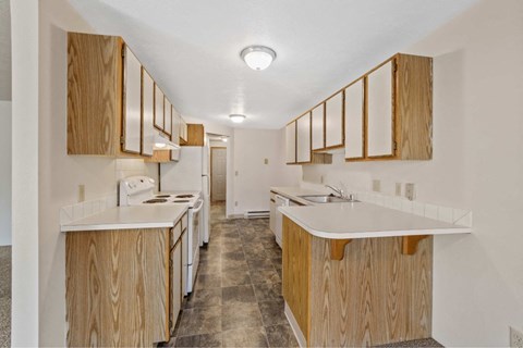 A kitchen with wooden cabinets and a white counter top.