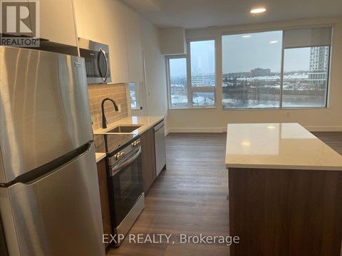 A kitchen with a refrigerator, oven, and sink.