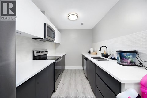 A kitchen with white cabinets and a microwave above the stove.