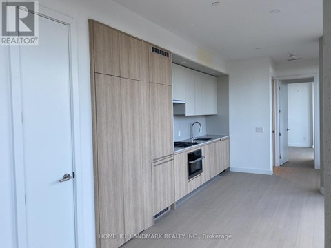 A kitchen with wooden cabinets and a white door.