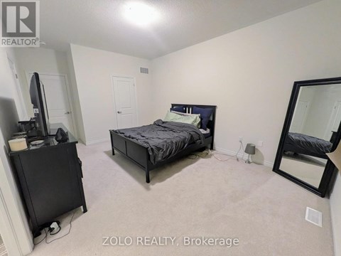 A bedroom with a bed, dresser, and mirror.