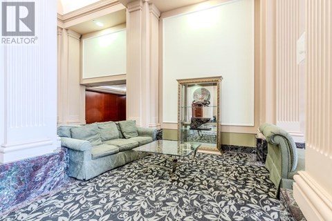 A living room with a grey couch and a large mirror.