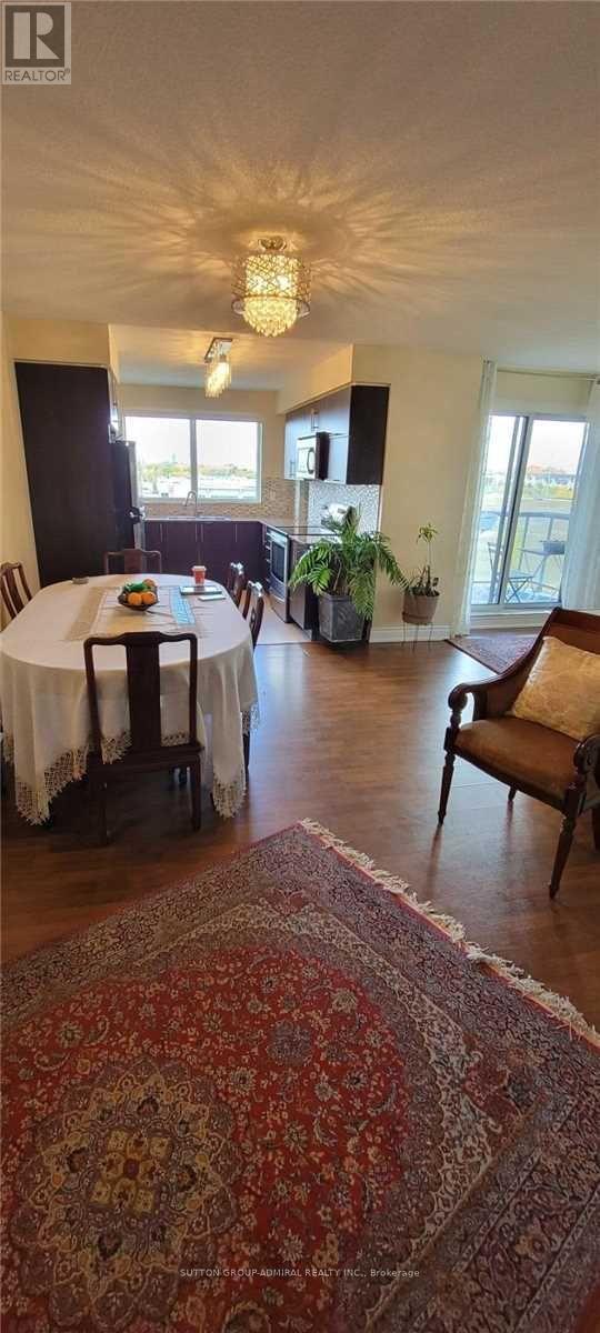 A dining room with a table set for four and a rug on the floor.