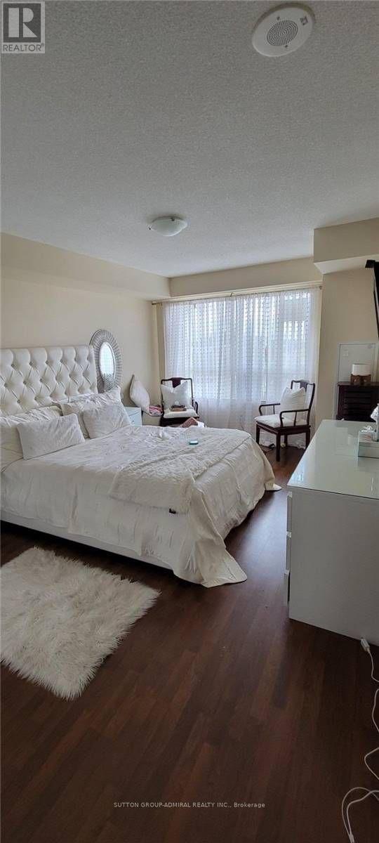 A bedroom with a white bed and a white ceiling.