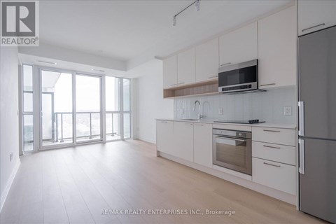 A kitchen with white cabinets and a microwave above the oven.