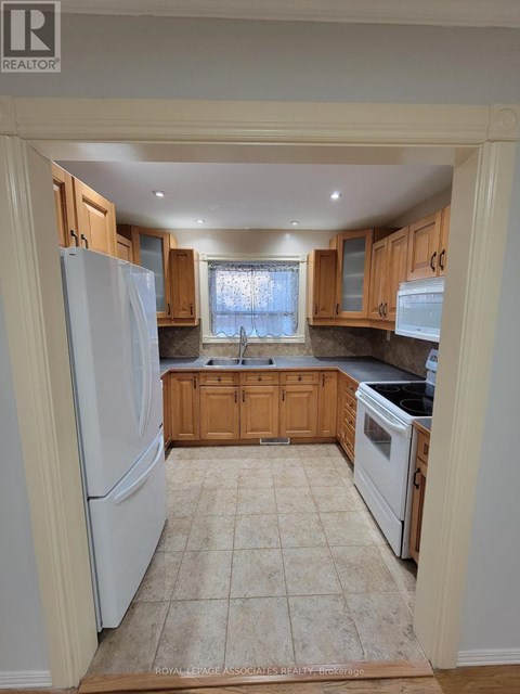 A kitchen with wooden cabinets and a white refrigerator.