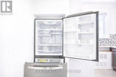 A white refrigerator with its door open in a kitchen.