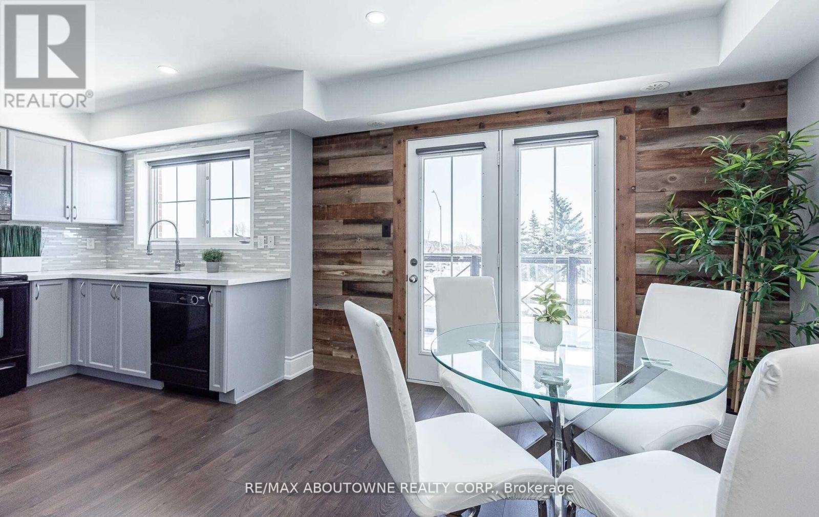 A modern kitchen with a glass table and white chairs.