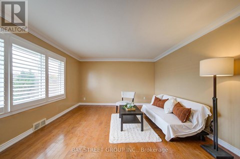 A living room with a white couch and a wooden floor.