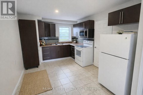 A kitchen with white appliances and brown cabinets.