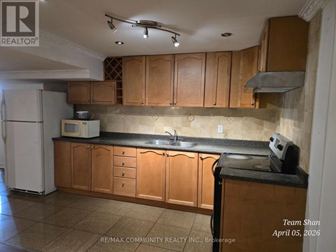A kitchen with wooden cabinets and a black countertop.