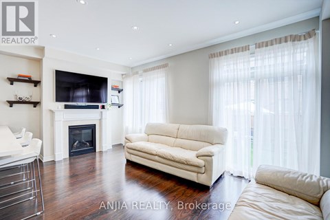 A living room with a white couch and a fireplace.