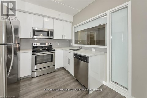 A modern kitchen with white cabinets and stainless steel appliances.