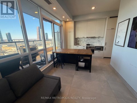 A modern kitchen with a view of the cityscape outside the large windows.