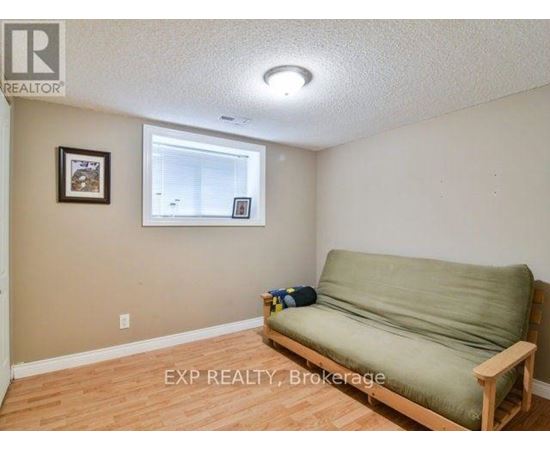 A living room with a couch, chairs, and a rug.