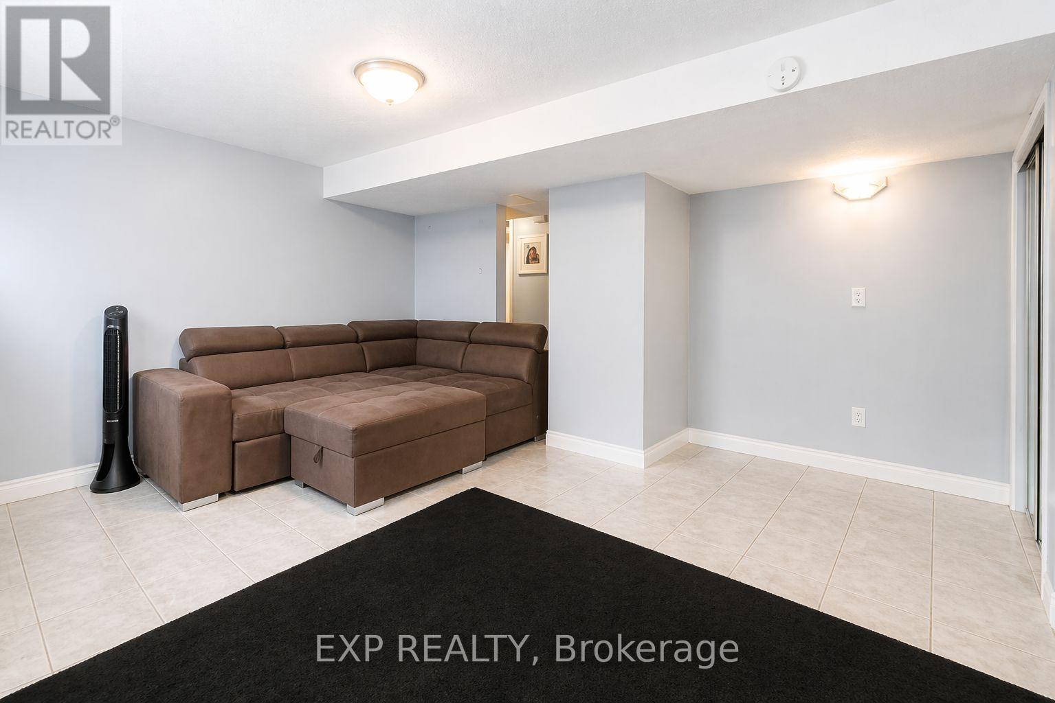 A kitchen with white cabinets and appliances, a rug on the floor, and a box of TJ Maxx on the counter.