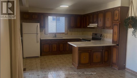 A kitchen with brown cabinets and a white refrigerator.
