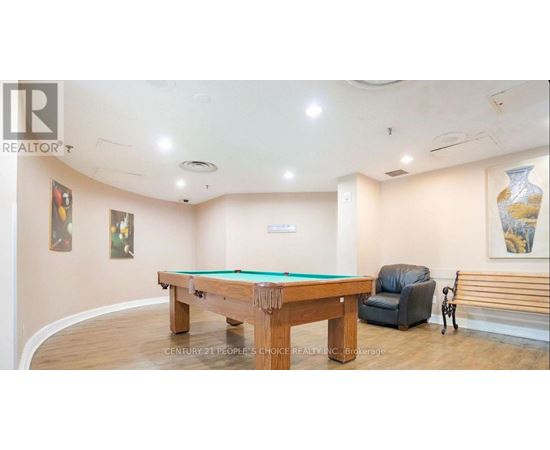 A pool table in a room with a chair and a vase.