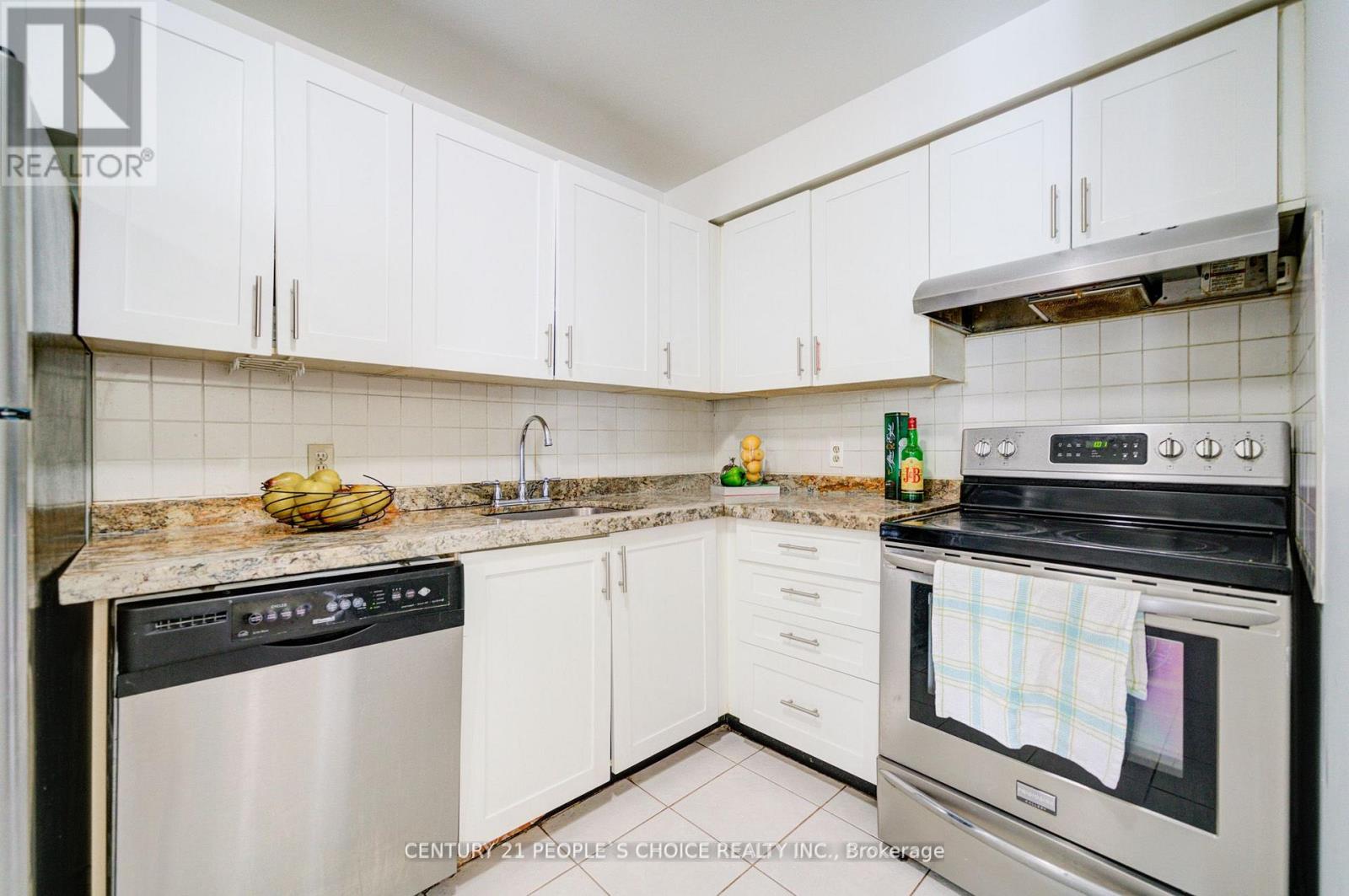 A kitchen with white cabinets and a black stove top oven.