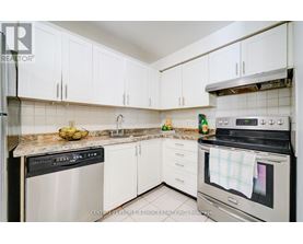A kitchen with white cabinets and a black stove top oven.