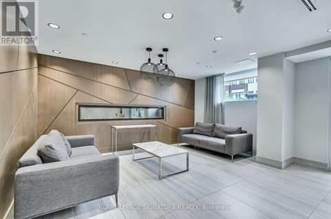 A modern living room with a grey sofa and a glass coffee table.