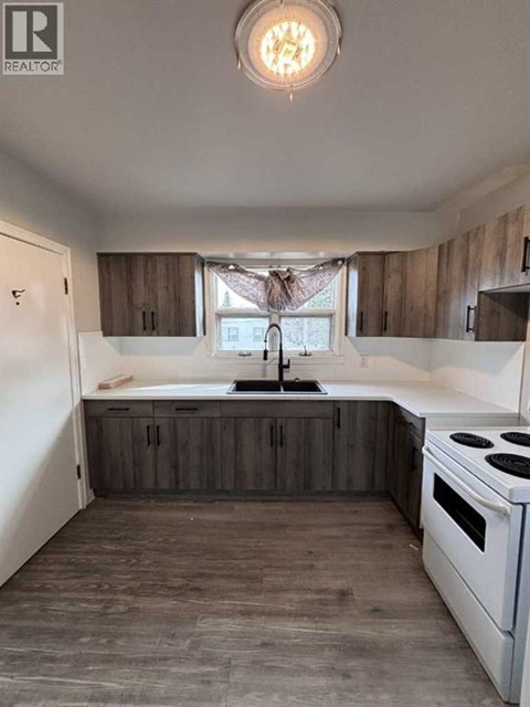 A kitchen with a white stove and wooden cabinets.