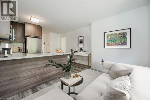 A living room with a couch, a coffee table, and a painting on the wall.