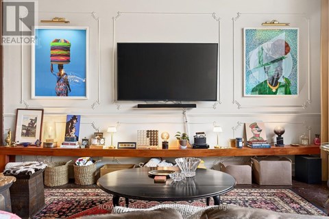 A living room with a black coffee table and a flat screen TV mounted on the wall.