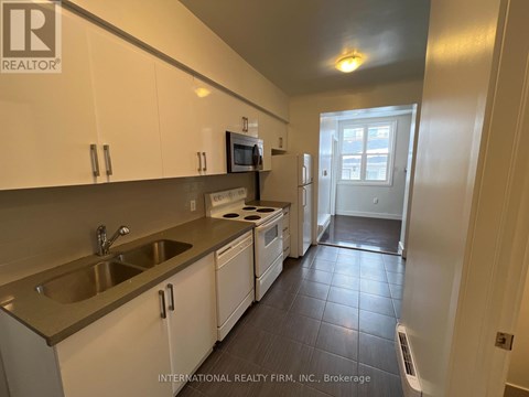A kitchen with white cabinets and a microwave above the stove.