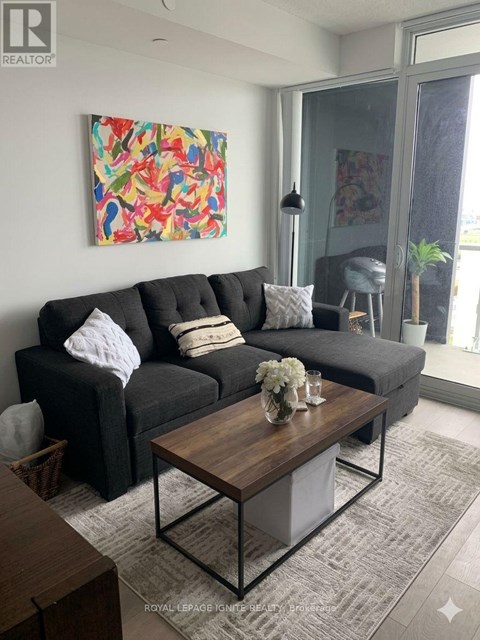 A living room with a grey couch and a wooden coffee table.