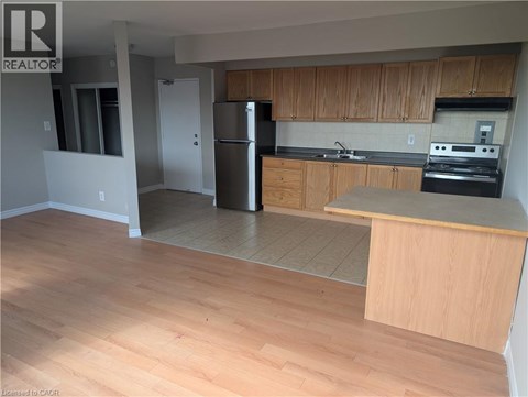 A kitchen with wooden cabinets and a refrigerator.