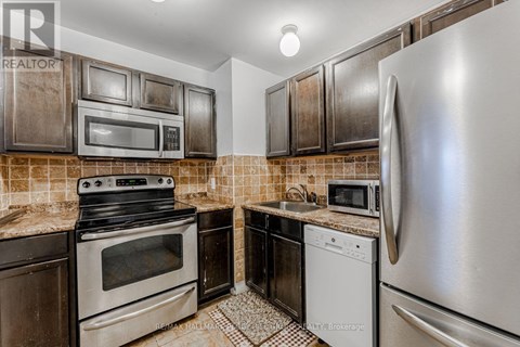A kitchen with a stove top oven, microwave, dishwasher, and refrigerator.