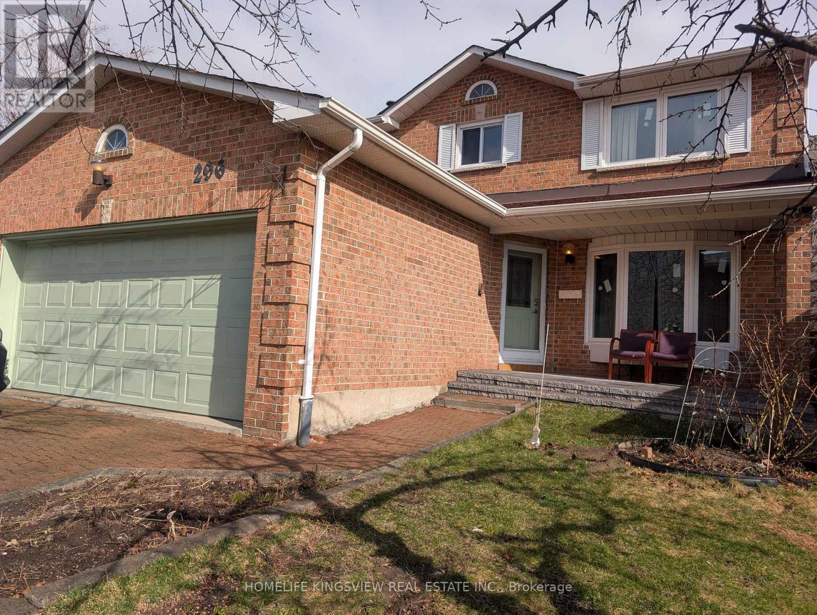 A brick house with a garage door and a sign that says "HOMELIFE KINGSVIEW REAL ESTATE INC Brokerage".