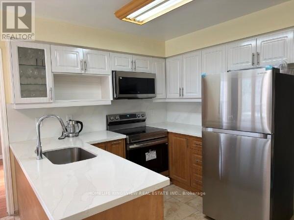 A kitchen with white cabinets and a stainless steel refrigerator.