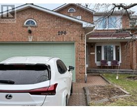 A white Lexus SUV is parked in front of a brick house with the number 296 on it.