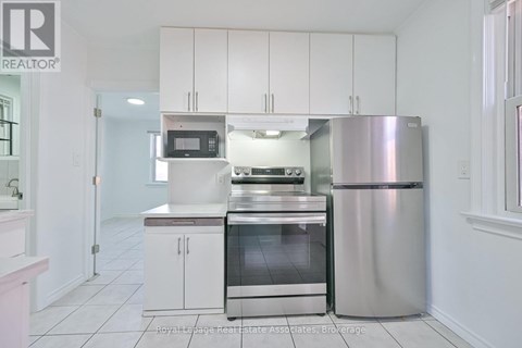 A kitchen with white cabinets and a stainless steel refrigerator.